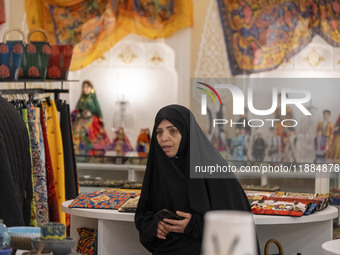 A veiled Iranian woman looks on while visiting the Iran Mall shopping mall in northwestern Tehran, Iran, on December 20, 2024, during Yalda...