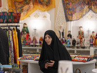 A veiled Iranian woman looks on while visiting the Iran Mall shopping mall in northwestern Tehran, Iran, on December 20, 2024, during Yalda...