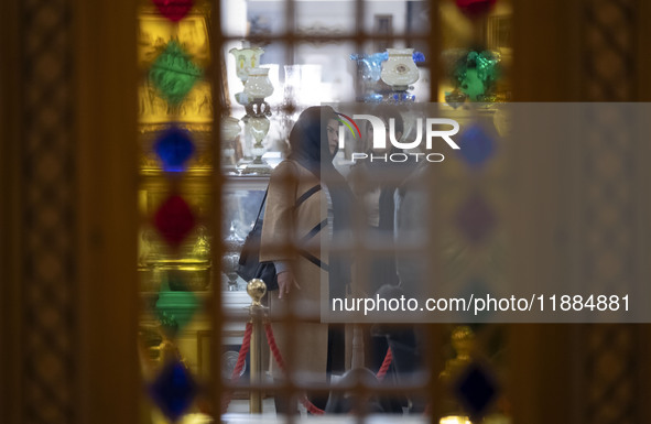 Two Iranian women stand at a handicraft shop while visiting the Iran Mall shopping mall in northwestern Tehran, Iran, on December 20, 2024,...