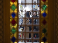 Two Iranian women stand at a handicraft shop while visiting the Iran Mall shopping mall in northwestern Tehran, Iran, on December 20, 2024,...