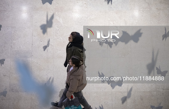 Two Iranian women walk at the Iran Mall shopping mall in northwestern Tehran, Iran, on December 20, 2024, during Yalda Night celebrations. Y...