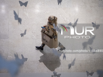 An Iranian woman walks at the Iran Mall shopping mall in northwestern Tehran, Iran, on December 20, 2024, during Yalda Night celebrations. Y...