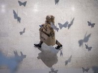 An Iranian woman walks at the Iran Mall shopping mall in northwestern Tehran, Iran, on December 20, 2024, during Yalda Night celebrations. Y...