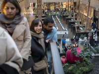 Iranian people stand next to a model of a pomegranate during Yalda Night celebrations at the Iran Mall shopping mall in northwestern Tehran,...