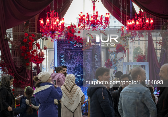 Iranian families stand in front of Yalda Night decorations at the Iran Mall shopping mall in northwestern Tehran, Iran, on December 20, 2024...