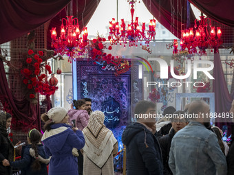 Iranian families stand in front of Yalda Night decorations at the Iran Mall shopping mall in northwestern Tehran, Iran, on December 20, 2024...