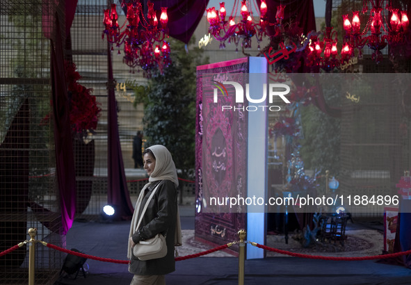 An Iranian woman walks past Yalda Night decorations at the Iran Mall shopping mall in northwestern Tehran, Iran, on December 20, 2024, durin...