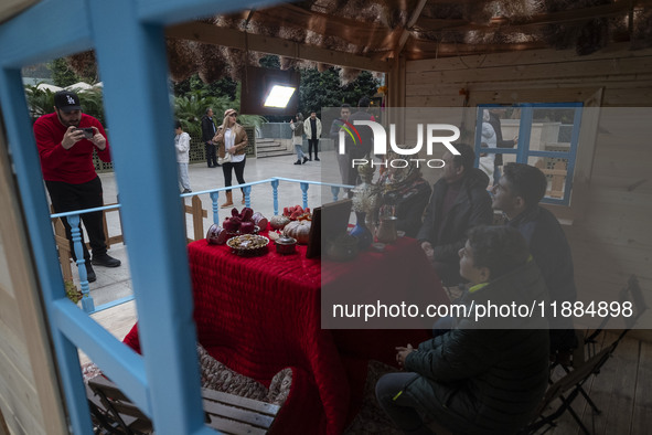 An Iranian family poses for a photograph with a Yalda table at the Iran Mall shopping mall in northwestern Tehran, Iran, on December 20, 202...