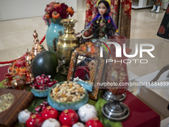 A young Iranian woman walks past a Yalda table while visiting the Iran Mall shopping mall in northwestern Tehran, Iran, on December 20, 2024...