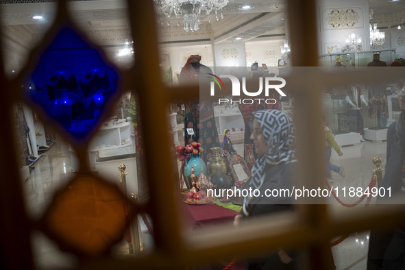 An Iranian woman walks past a Yalda table while visiting the Iran Mall shopping mall in northwestern Tehran, Iran, on December 20, 2024, dur...