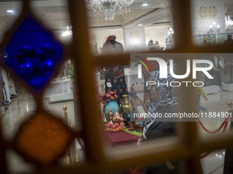 An Iranian woman walks past a Yalda table while visiting the Iran Mall shopping mall in northwestern Tehran, Iran, on December 20, 2024, dur...