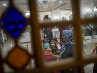 An Iranian woman walks past a Yalda table while visiting the Iran Mall shopping mall in northwestern Tehran, Iran, on December 20, 2024, dur...