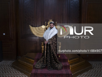 An Iranian man wears symbolic dresses as a King and poses for a photograph while visiting the Iran Mall shopping mall in northwestern Tehran...