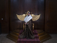 An Iranian man wears symbolic dresses as a King and poses for a photograph while visiting the Iran Mall shopping mall in northwestern Tehran...