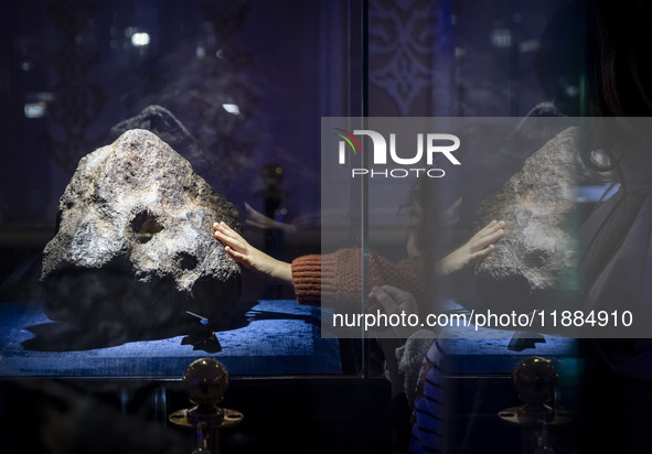 A young Iranian girl touches a meteorite at the meteorite museum while visiting the Iran Mall shopping mall in northwestern Tehran, Iran, on...