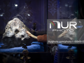 A young Iranian girl touches a meteorite at the meteorite museum while visiting the Iran Mall shopping mall in northwestern Tehran, Iran, on...