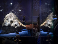 A young Iranian girl touches a meteorite at the meteorite museum while visiting the Iran Mall shopping mall in northwestern Tehran, Iran, on...