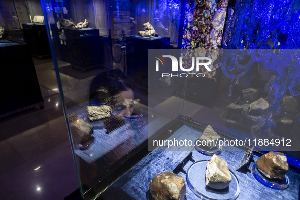 A young Iranian girl observes meteorites at the meteorite museum while visiting the Iran Mall shopping mall in northwestern Tehran, Iran, on...