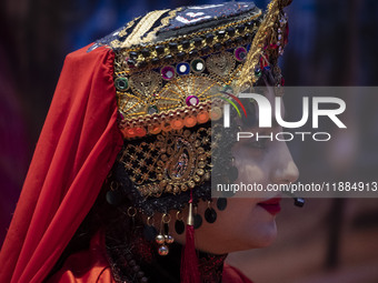 A young Iranian woman wearing a traditional hat looks on as she performs during Yalda Night celebrations at the Iran Mall shopping mall in n...