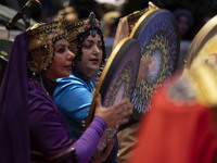 Two women wearing Iranian traditional dresses play traditional musical instruments during Yalda Night celebrations at the Iran Mall shopping...