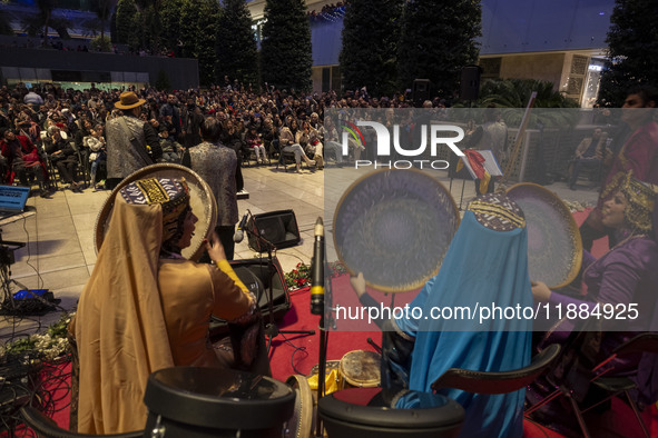 Women wearing Iranian traditional dresses play traditional musical instruments during Yalda Night celebrations at the Iran Mall shopping mal...