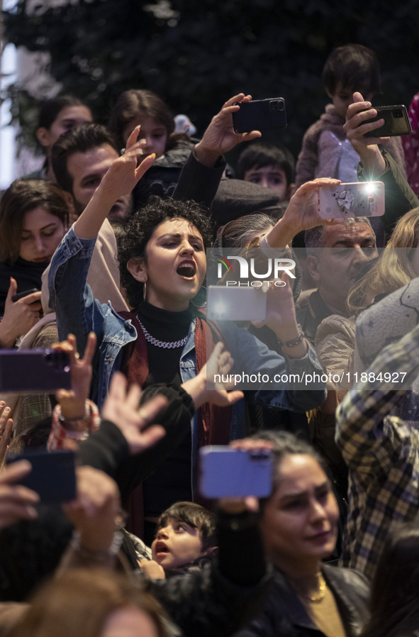 A young Iranian woman reacts while participating in Yalda Night celebrations at the Iran Mall shopping mall in northwestern Tehran, Iran, on...