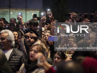 Iranian families capture videos with their cellphones while participating in Yalda Night celebrations at the Iran Mall shopping mall in nort...