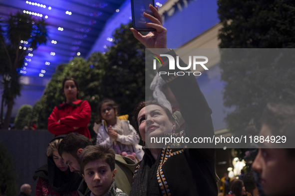 An Iranian woman records videos with her cellphone while participating in Yalda Night celebrations at the Iran Mall shopping mall in northwe...