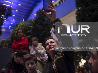 An Iranian woman records videos with her cellphone while participating in Yalda Night celebrations at the Iran Mall shopping mall in northwe...