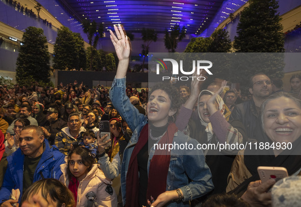 Iranian women react while participating in Yalda Night celebrations at the Iran Mall shopping mall in northwestern Tehran, Iran, on December...