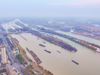 Cargo ships loaded with agricultural supplies, building materials, coal, and other goods sail on the Beijing-Hangzhou Grand Canal in Suqian,...