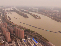 Cargo ships loaded with agricultural supplies, building materials, coal, and other goods sail on the Beijing-Hangzhou Grand Canal in Suqian,...