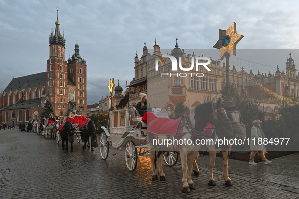 KRAKOW, POLAND - DECEMBER 20:   
Horse-drawn carriages waiting for tourists at Krakow's Main Market Square, on December 20, 2024 in Krakow,...