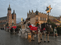 KRAKOW, POLAND - DECEMBER 20:   
Horse-drawn carriages waiting for tourists at Krakow's Main Market Square, on December 20, 2024 in Krakow,...