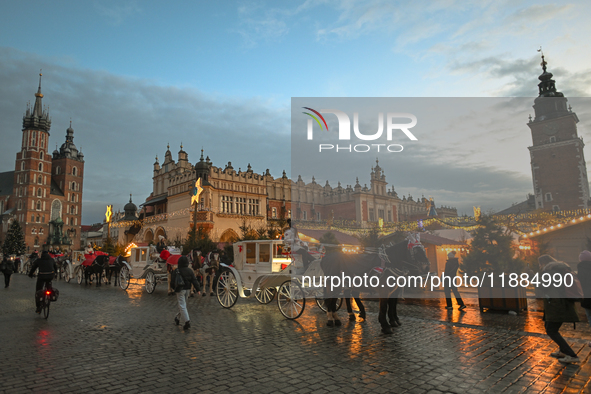 KRAKOW, POLAND - DECEMBER 20:   
Horse-drawn carriages waiting for tourists at Krakow's Main Market Square, on December 20, 2024 in Krakow,...