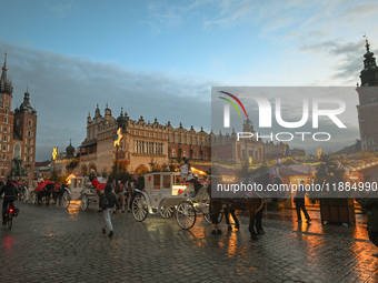 KRAKOW, POLAND - DECEMBER 20:   
Horse-drawn carriages waiting for tourists at Krakow's Main Market Square, on December 20, 2024 in Krakow,...