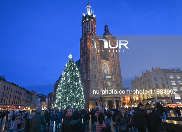 KRAKOW, POLAND - DECEMBER 20:   
An illuminated Christmas tree stands near St. Mary's Basilica in Krakow's UNESCO-listed Main Square, on Dec...