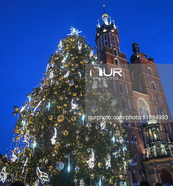 KRAKOW, POLAND - DECEMBER 20:   
An illuminated Christmas tree stands near St. Mary's Basilica in Krakow's UNESCO-listed Main Square, on Dec...