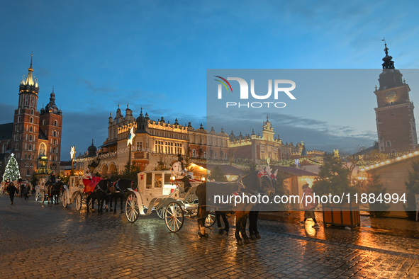 KRAKOW, POLAND - DECEMBER 20:   
Horse-drawn carriages waiting for tourists at Krakow's Main Market Square, on December 20, 2024 in Krakow,...