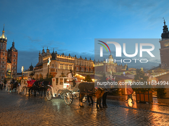 KRAKOW, POLAND - DECEMBER 20:   
Horse-drawn carriages waiting for tourists at Krakow's Main Market Square, on December 20, 2024 in Krakow,...