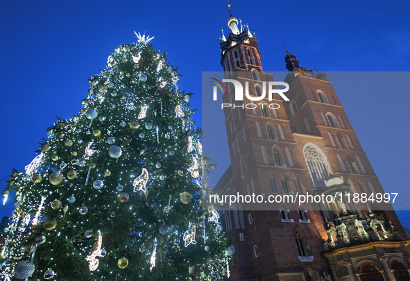 KRAKOW, POLAND - DECEMBER 20:   
An illuminated Christmas tree stands near St. Mary's Basilica in Krakow's UNESCO-listed Main Square, on Dec...