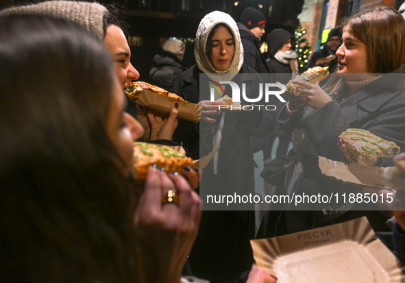 KRAKOW, POLAND - DECEMBER 20:   
People enjoy a traditional 'zapiekanka' - a toasted open-face sandwich with sliced baguette, sauteed white...