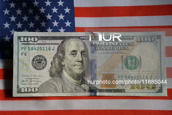 U.S. dollars and a U.S. flag are seen in Shanghai, China, on December 21, 2024. 