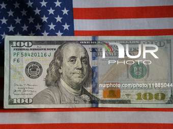 U.S. dollars and a U.S. flag are seen in Shanghai, China, on December 21, 2024. (