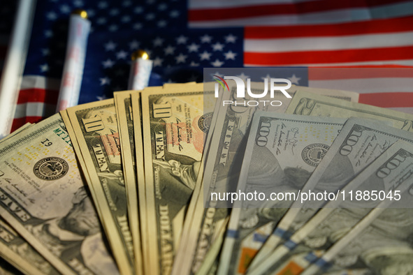 U.S. dollars and a U.S. flag are seen in Shanghai, China, on December 21, 2024. 