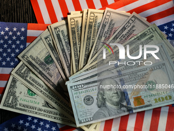 U.S. dollars and a U.S. flag are seen in Shanghai, China, on December 21, 2024. (