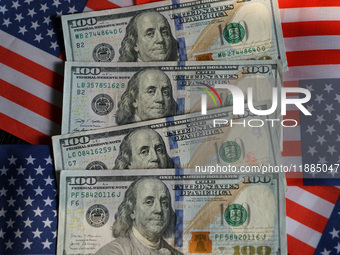 U.S. dollars and a U.S. flag are seen in Shanghai, China, on December 21, 2024. (