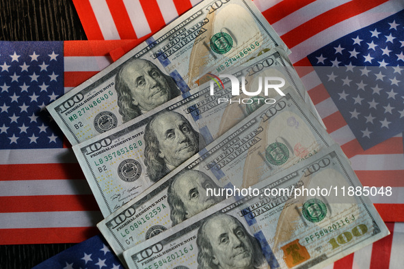 U.S. dollars and a U.S. flag are seen in Shanghai, China, on December 21, 2024. 