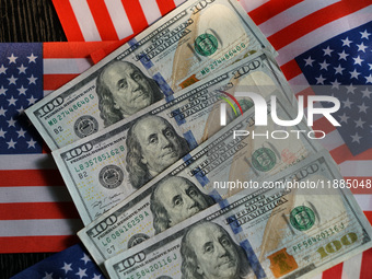 U.S. dollars and a U.S. flag are seen in Shanghai, China, on December 21, 2024. (