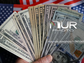 U.S. dollars and a U.S. flag are seen in Shanghai, China, on December 21, 2024. (